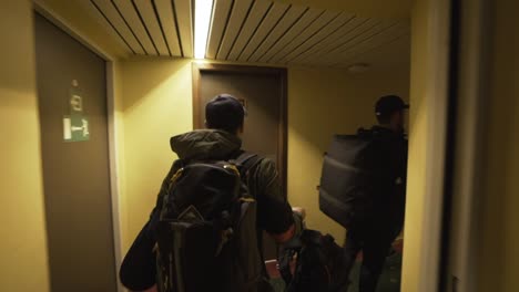 Backpackers-with-travel-suitcase-walking-at-hotel-corridor