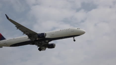 Delta-Commercial-Plane-Arrives-For-Landing,-Over-Freeway,-Close-Up,-Slow-Motion