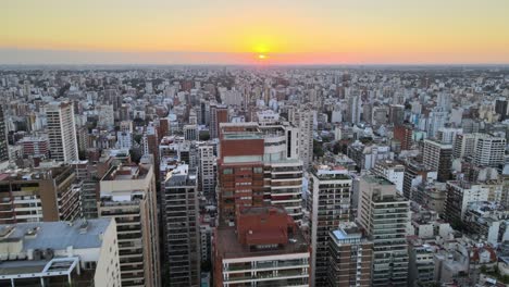 Dolly-in-flying-over-Belgrano-neighborhood-tall-buildings-at-sunset,-Buenos-Aires,-Argentina
