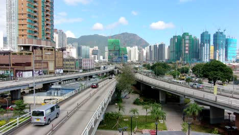 Hong-Kong-downtown-Kowloon-urban-area,-Low-angle-aerial-view-with-traffic-and-city-skyscrapers