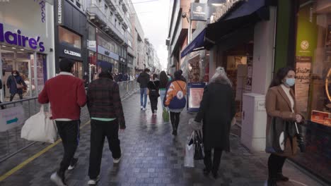 POV-walking-in-crowded-shopping-street-Rue-Neuve-in-Brussels,-Belgium-during-corona-pandemic