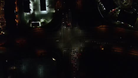 Over-head-clip-of-a-intersection-at-night-with-Cars-turning-through-it