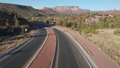 Scenic-view-of-freeway-in-Arizona-with-red-rock-formation-at-background,-aerial