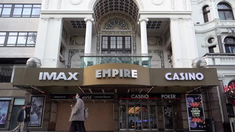 People-cycle-and-walk-past-the-boarded-up-Empire-Imax-Cinema-on-Leicester-Square-during-the-second-national-Coronavirus-lockdown