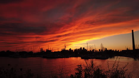 Wenn-Die-Nacht-Hereinbricht,-Hängen-Stimmungsvolle-Rote-Wolken-Wie-Eine-Decke-über-Dem-Bootshafen-Und-Der-Skyline-Der-Stadt