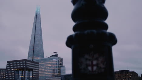 The-emblem-of-the-City-of-London-on-a-lamppost-and-The-Shard-in-London