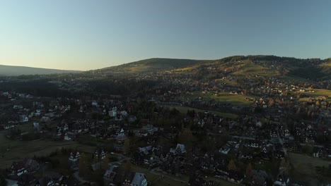 Aerial-above-Zakopane-in-rural-valley-with-first-golden-sunlight-of-sunrise