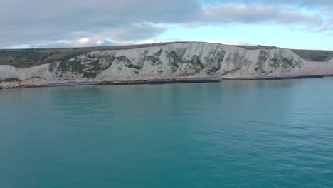 Rising-aerial-drone-shot-from-the-sea-towards-the-white-cliffs-of-dover