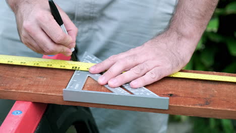 Carpenter-Prepares-Wood-for-Woodworking-Project,-Slow-Motion-Taking-of-Measurements-on-Wood-Plank