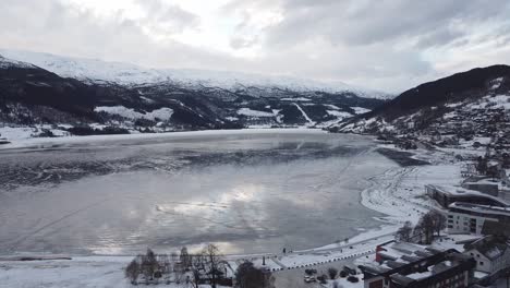Antena-Moviéndose-Sobre-Voss-Y-Mostrando-El-Lago-Vangsvatnet-Congelado-Cerca-De-Hoteles-Y-Carreteras