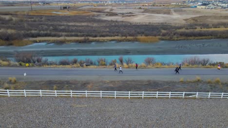 People-run-along-a-riverside-trail-in-support-of-a-community-event---aerial-view