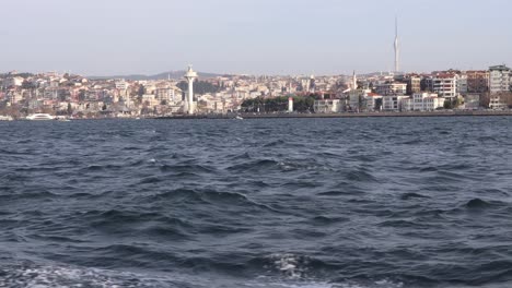Vista-Desde-Un-Barco-Navegando-En-El-Bósforo-Con-Edificios-De-La-Ciudad-Y-Torres-En-Uskudar,-Estambul,-Turquía