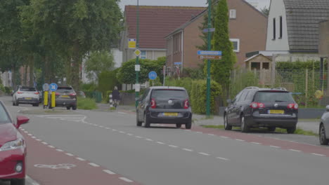 Busy-road-in-the-Netherlands-with-a-female-cyclist-crossing-the-road