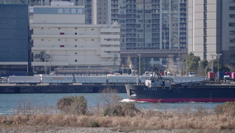 Cargo-Ship-Passing-By-In-Waterfront-Manufacturing-Warehouse-By-Tokyo-Bay-In-Japan