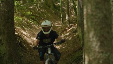 Mountain-biker-carves-down-gully-and-kicks-up-dust-under-a-light-ray