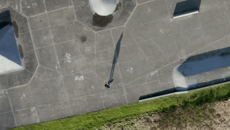 Aerial-drone-view-of-a-skater-practicing-flips-at-a-skate-park