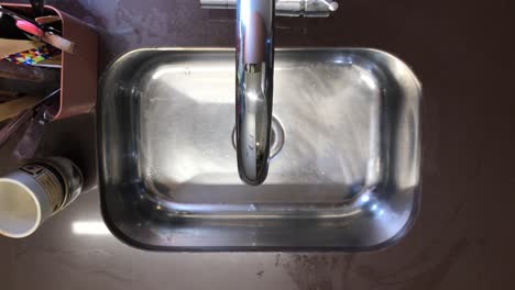 Mann-Wäscht-Und-Bereitet-Kolibri-Futterstation-Vor,-Aufnahme-über-Dem-Waschbecken