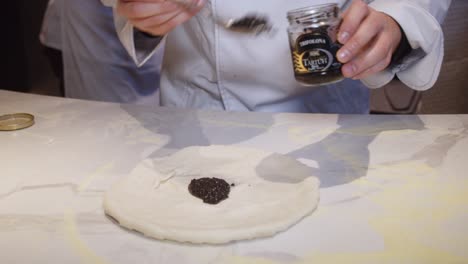 Chef-adds-truffle-salsa-onto-the-pizza-dough