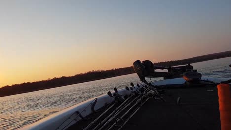Early-morning-bass-boat-arriving-at-a-fishing-spot-with-the-sun-rising-in-the-distance