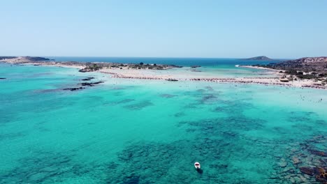 Boat-anchored-in-the-beautiful-coral-waters-of-Elafonisi,-Crete-aerial