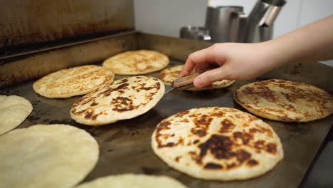 Professional-Chef-Cooking-and-Flipping-Roti-Indian-Flat-bread-on-Commercial-Hot-Plate-in-the-Kitchen