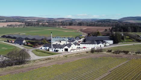 Aerial-view-of-Fettercairn-whisky-distillery-on-a-sunny-spring-day,-Aberdeenshire,-Scotland