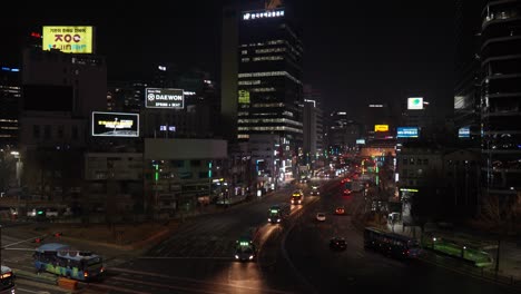 City-life-at-night-at-a-downtown-intersection-in-Seoul,-South-Korea-at-nighttime---slow-motion