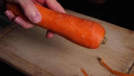 Caucasian-chef-hands-peels-a-carrot-with-a-green-peeler-In-slow-motion