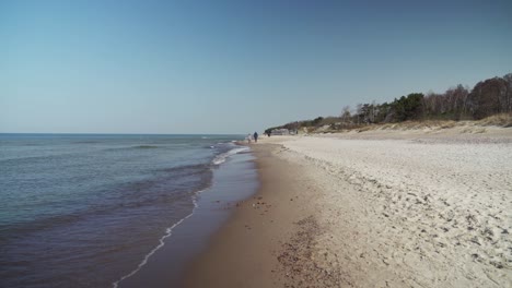 Pareja-Caminando-Por-La-Playa-De-Melnrage-En-Klaipeda-En-Un-Día-Soleado-Cerca-Del-Mar-Báltico