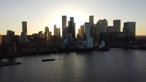 Aerial---Sunset-over-River-Thames-and-Canary-Wharf,-London,-UK,-wide-pan-right