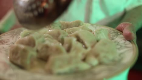 Close-up-shot-of-a-chef-plating-freshly-boiled-dumplings