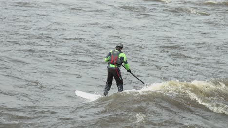 Longboard-Surfer-Reitet-Auf-Dem-Kielwasser-Des-Ottawa-River,-Der-Aus-Den-Stromschnellen-Auf-Bate-Island-Entsteht