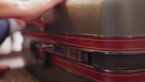 Detail-of-female-hands-closing-suitcase-with-clothes