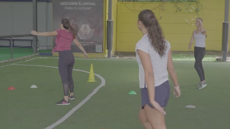 Mujeres-Entrenando-En-El-Campo-De-Fútbol-Con-Conos-Al-Lado-Del-Entrenador
