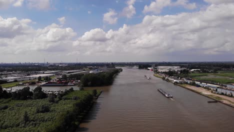 High-Aerial-View-Ship-Travelling-Along-River-Noord-In-Netherlands-With-Marina-In-View