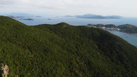 Flying-over-tropical-hill-revealing-majestic-Vietnam-island-archipelago-with-small-town