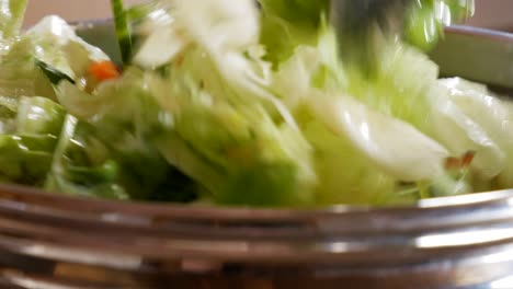 Mixing-tender-and-moist-vibrant-salads-in-close-up-static-view