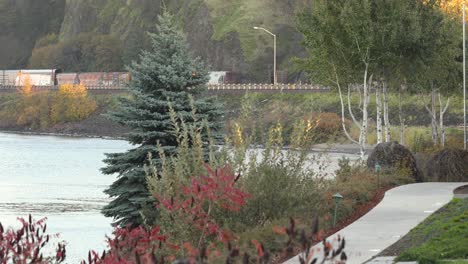 Garten-Am-Flussufer,-Autobahnverkehr-Und-Güterzug-Im-Hintergrund,-Hood-River,-USA