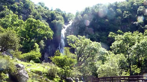 People-walking-idyllic-Aber-falls-Snowdonia-mountain-Welsh-national-park-waterfall-wilderness