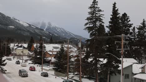 Escena-Invernal-De-La-Ciudad-De-Banff-Cubierta-De-Nieve,-Montaña-Cubierta-De-Nieve-En-La-Distancia