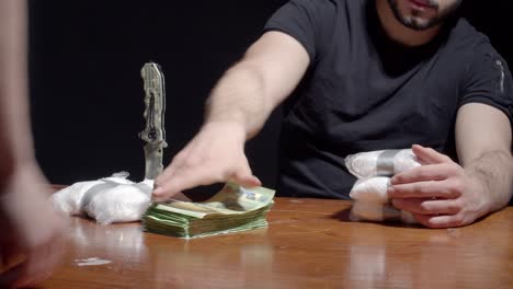 Cropped-Image-Of-A-Man-Trading-Packs-Of-Powdered-Cocaine-Drug-With-Money