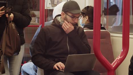 Passengers-get-off-the-train-passing-a-caucasian-man-with-a-laptop