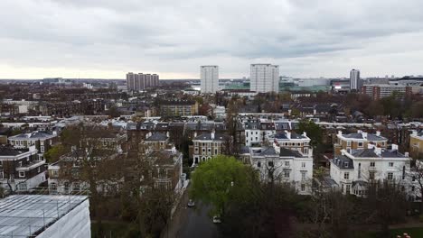 Aufsteigende-Luftaufnahme-über-Einem-Wohngebiet-In-London-Und-Hohen-Häuserblöcken-Im-Hintergrund