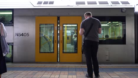 Transport-Von-Sydney-Zügen,-Die-Tür-Schließt-Sich-Und-Ein-Männlicher-Mann-Wartet-Auf-Den-Zug-Am-Hauptbahnhof-Von-Sydney,-New-South-Wales,-Australien