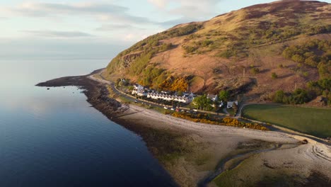 Aerial-view-of-the-Scottish-town-of-Catacol-on-the-Isle-of-Arran-at-sunset,-Scotland