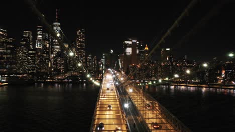 A-slow-drone-shot-of-the-NYC-skyline-from-the-Brooklyn-Bridge-at-night