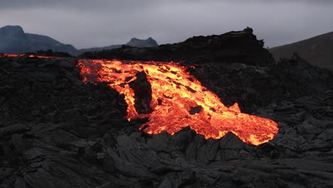 Impresionante-Paisaje-Islandés-Con-Volcanes-Y-Lava-Que-Fluye-A-Través-De-Rocas-Negras