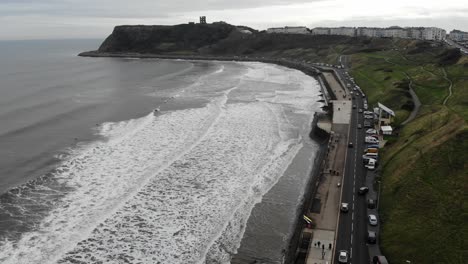 Surfers-paddle-out-to-ride-the-waves-in-Scarborough,-Yorkshire,-UK