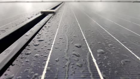 Rain-dripping-gently-on-solar-panel-with-silicon-solar-cells-and-drops-flow-gently-downwards-on-panel---Closeup-of-wet-solar-panel-with-silicon-circuits