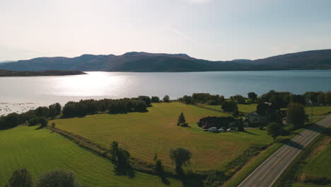 Glitzerndes-Wasser-Des-Skjerstad-Fjords-Von-Einer-Leeren-Straße-In-Der-Nähe-Eines-Landhauses-In-Nordland,-Norwegen